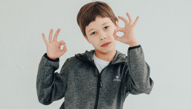A young boy making the sign for OK with both hands. Image by Victoria from Pixabay.&nbsp;